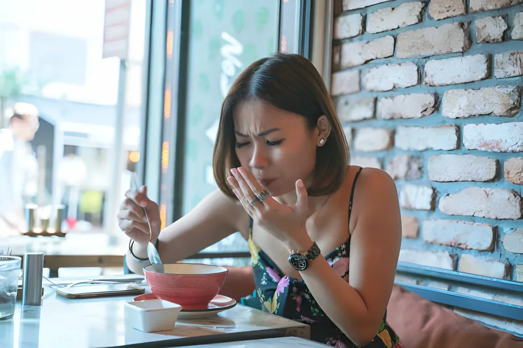 mujer mostrando expresión de dolor por tomar alimentos calientes