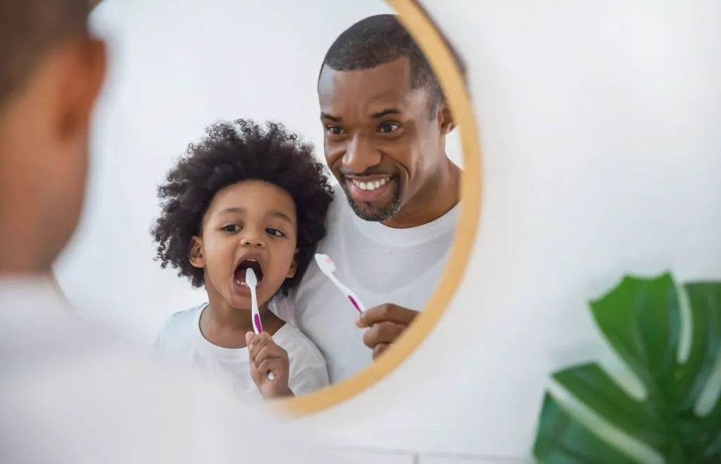 padre e hijo cepillándose los dientes